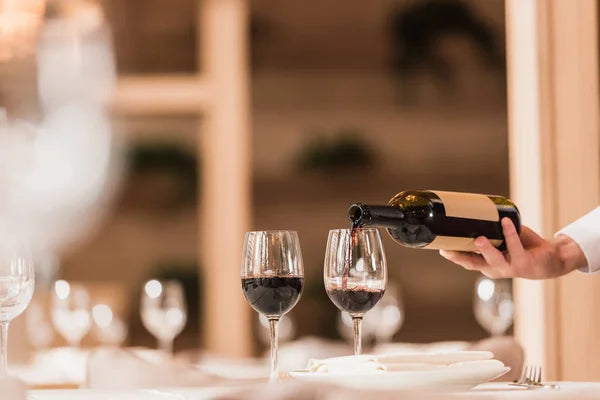 depositphotos_172614074-stock-photo-waiter-pouring-red-wine