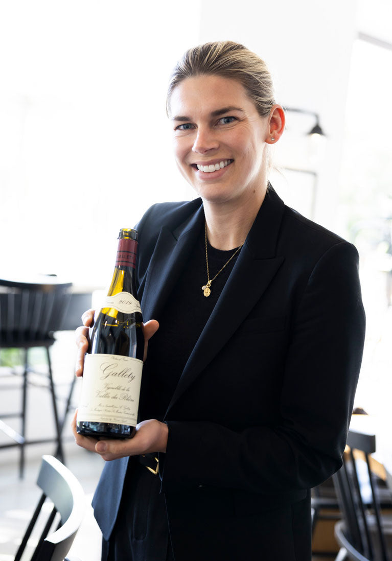 Argaux Sommlier for hire, holding curated bottle of wine.